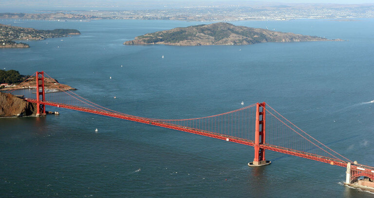 Aerial view of the iconic golden gate bridge spanning the entrance to san francisco bay with hills in the background.